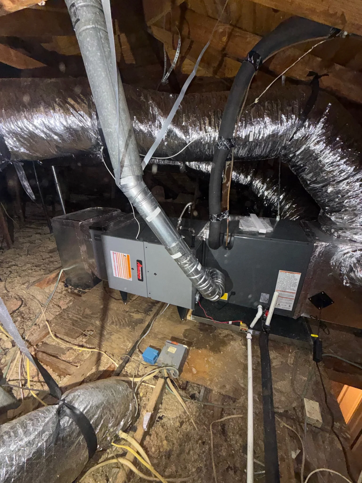 HVAC unit with dual flex ducts and reflective insulation in attic installation